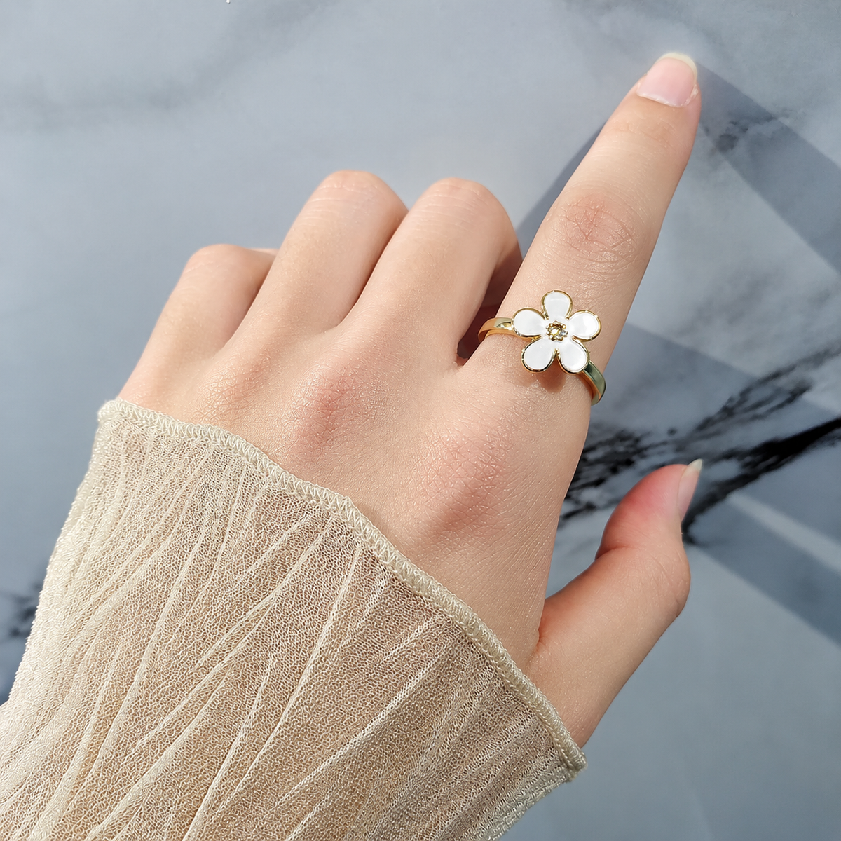 Bague anti-stress rotative Fleur Design couleur blanche portée au doigt