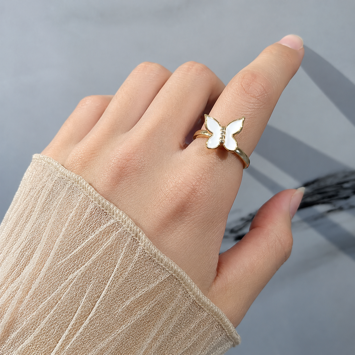 Bague anti-stress rotative Papillon portée au doigt.