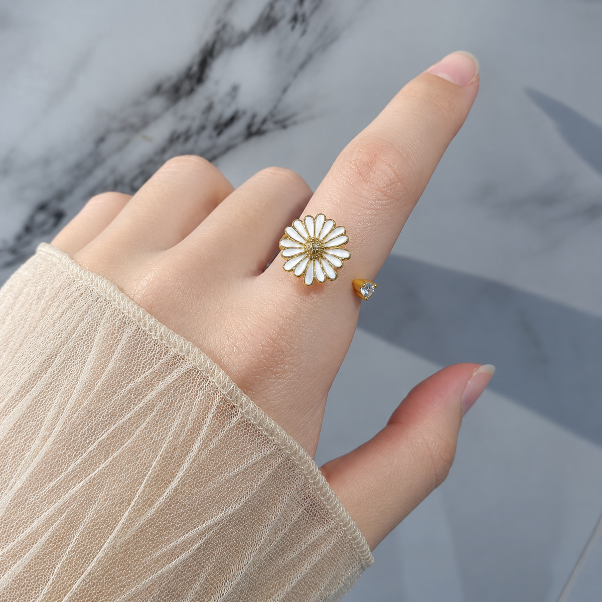 Bague anti-stress rotative Pâquerette couleur or portée au doigt