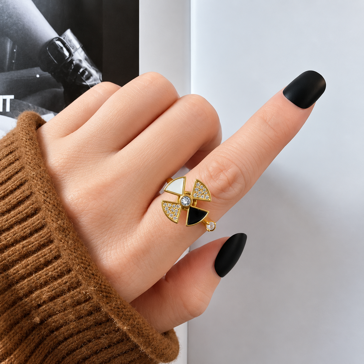 Bague anti-stress rotative Triangle Céleste dorée, quatre triangles noir, blanc nacré et pavés, portée au doigt