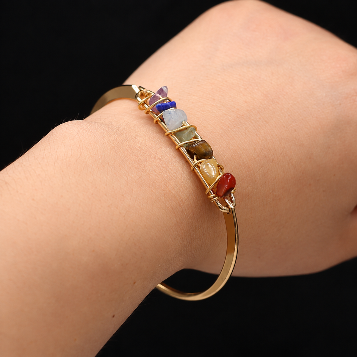 Bracelet 7 Chakras Luxara, jonc doré orné de sept éclats de pierres enroulés de fil doré, porté au poignet