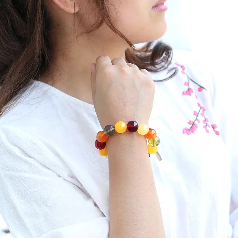 Bracelet Ambre Multicolore, grosses perles d’ambre multicolores cerise, miel et jaune, porté au poignet