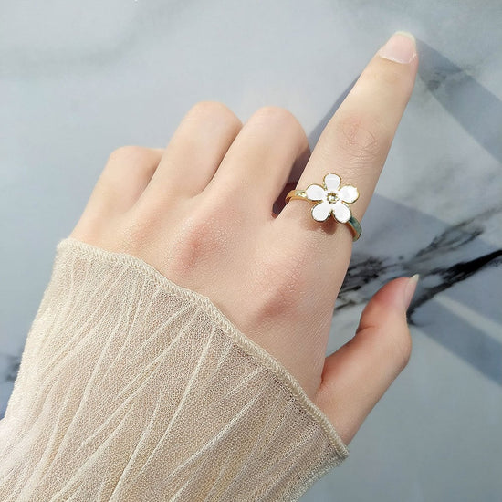 Bague anti-stress rotative Fleur Design couleur blanche portée au doigt